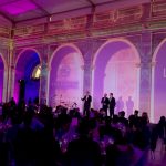 Performers next to an audience in a corporate dinner.