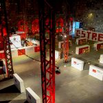 Aerial view of the inside of a brick building decorated with brand materials and lights.