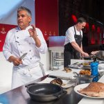 Man filming chefs cooking a dish during an event.